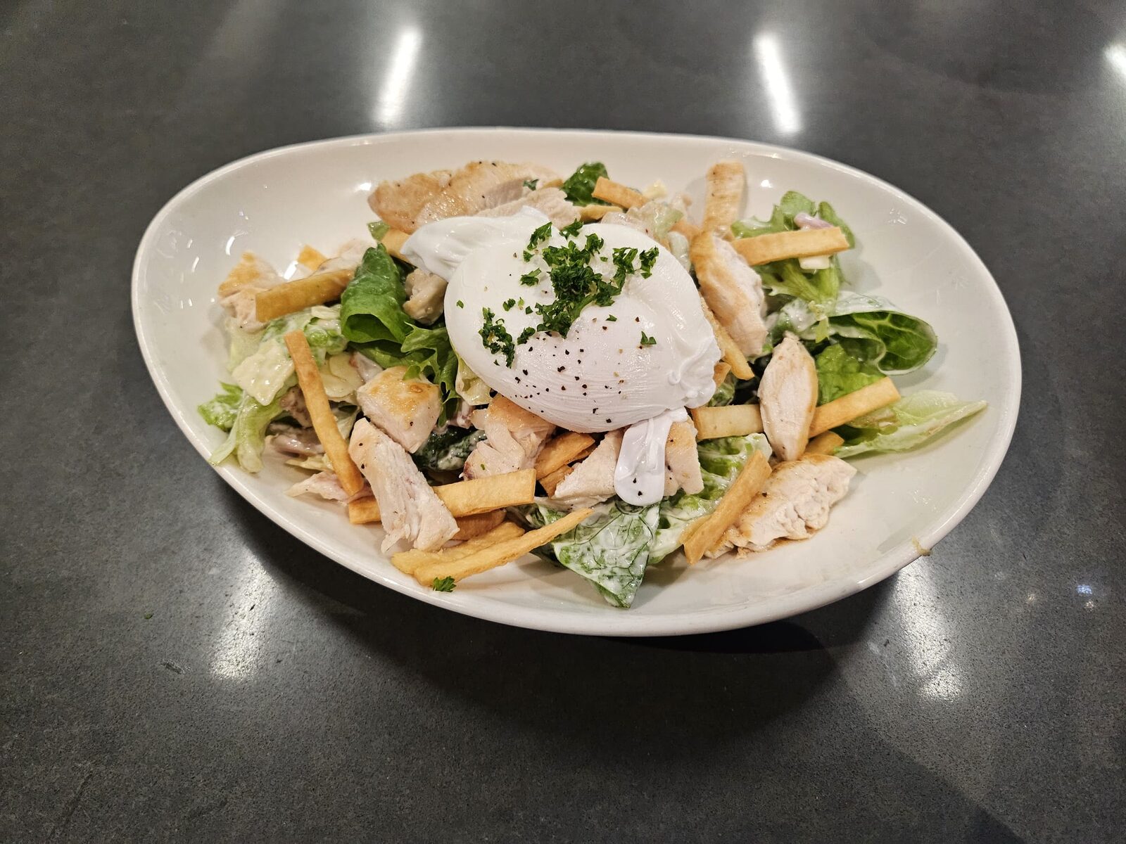 Caesar salad with chicken and a poached egg